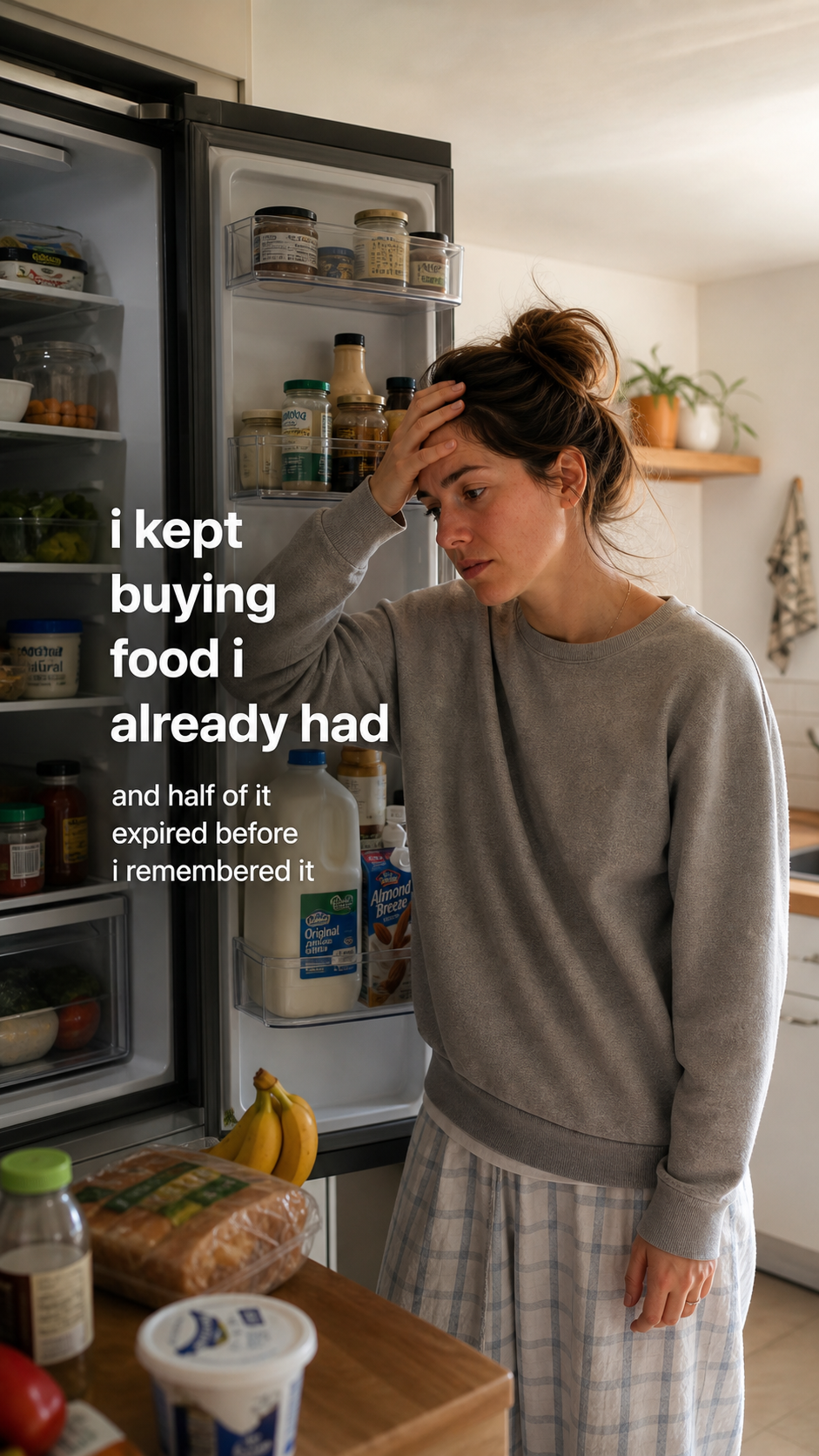 A person standing in front of an open fridge, overwhelmed by groceries already inside.